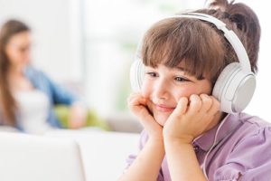 little girl wearing headphones in visual modeling aba therapy